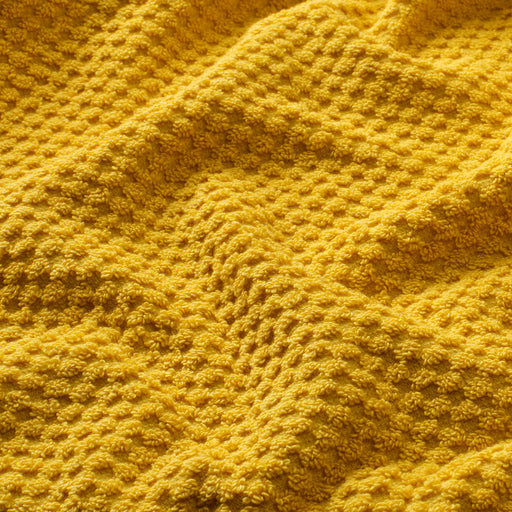 Close-up of IKEA GULVIAL golden-yellow terry hand towel showing soft fluffy texture and weave