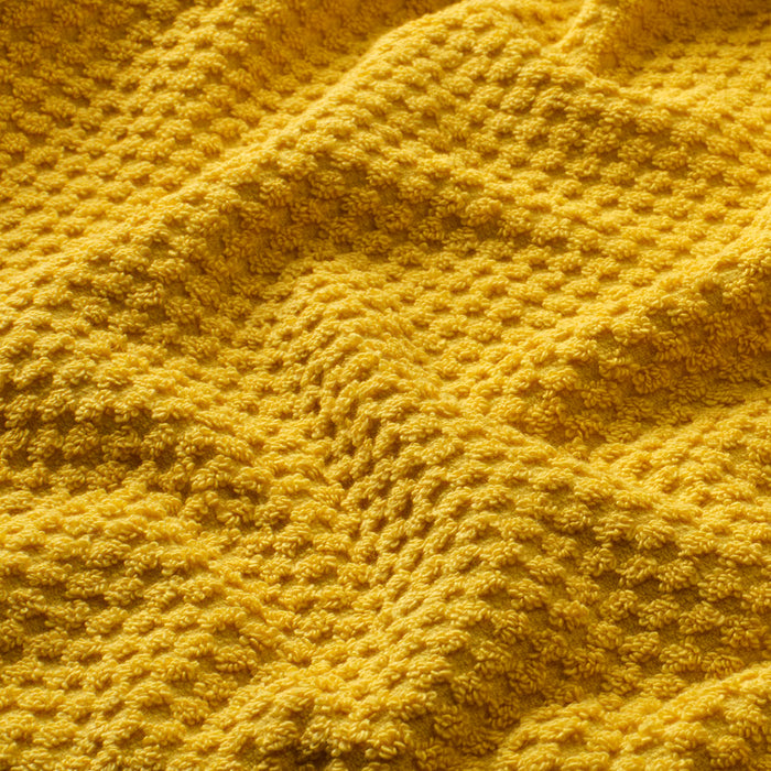 Close-up of IKEA GULVIAL golden-yellow terry hand towel showing soft fluffy texture and weave
