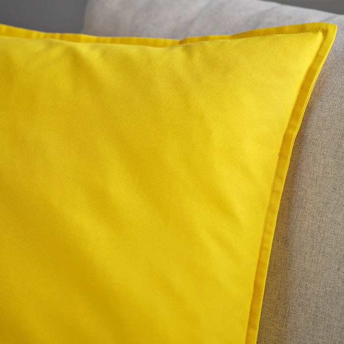 IKEA GURLI yellow cushion cover laid flat on a bed showing bright colour and neat stitching