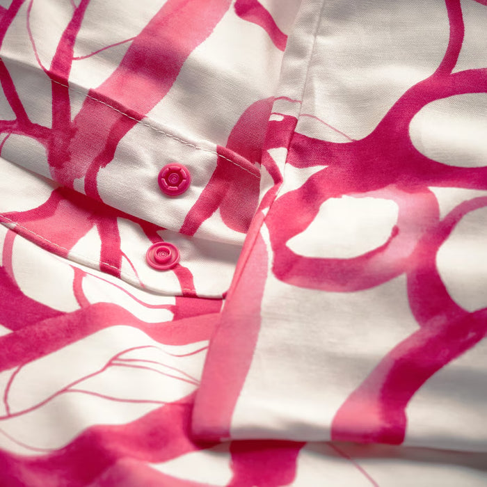IKEA HÄRLIR duvet cover and matching pillowcases laid flat, white bright pink floral pattern
