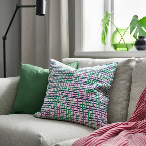 Decorative HAMNKRASSING Cushion Cover in pink and blue-green, placed on a modern couch.90582800         