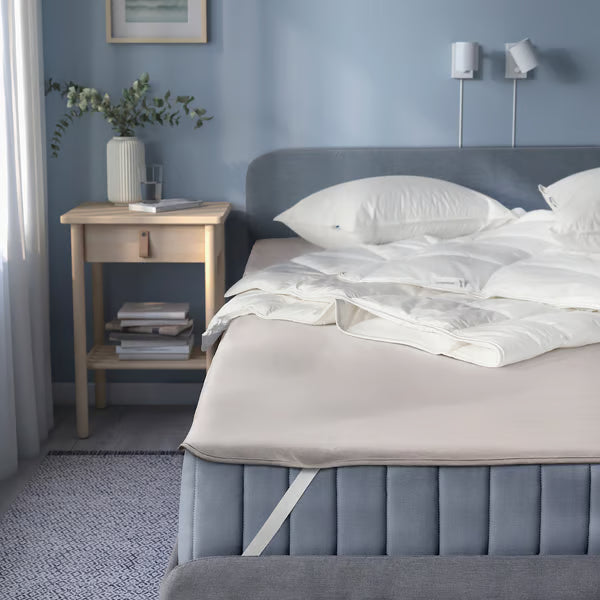  IKEA HAMPPALM grey waterproof mattress protector fitted on large bed with white bedding bedroom setting