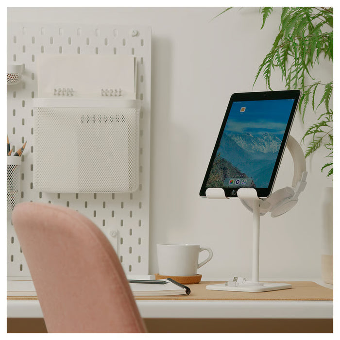 IKEA HAVREHOJ white tablet stand on clean desk with tablet displaying landscape, peach chair in background