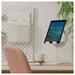 IKEA HAVREHOJ white tablet stand on clean desk with tablet displaying landscape, peach chair in background