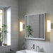 Modern bathroom with a mirror, sink, and decorative elements.