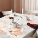 Table set with IKEA HAVSGÄDDA pink bowls and white cups on white cloth