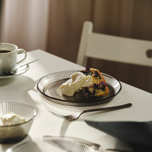 IKEA HAVSGÄDDA grey glass side plate serving a slice of cake with whipped cream, with coffee and glassware