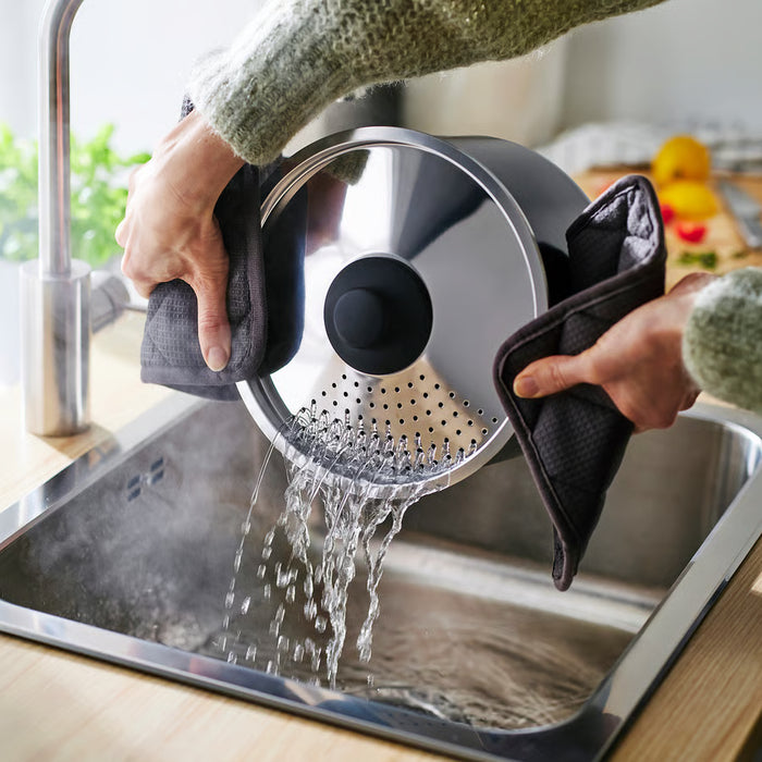 Pouring water out through IKEA HEMLAGAD pot lid into sink