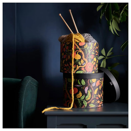 IKEA HÖSTAGILLE round storage boxes stacked showing lid and black interior autumn floral design