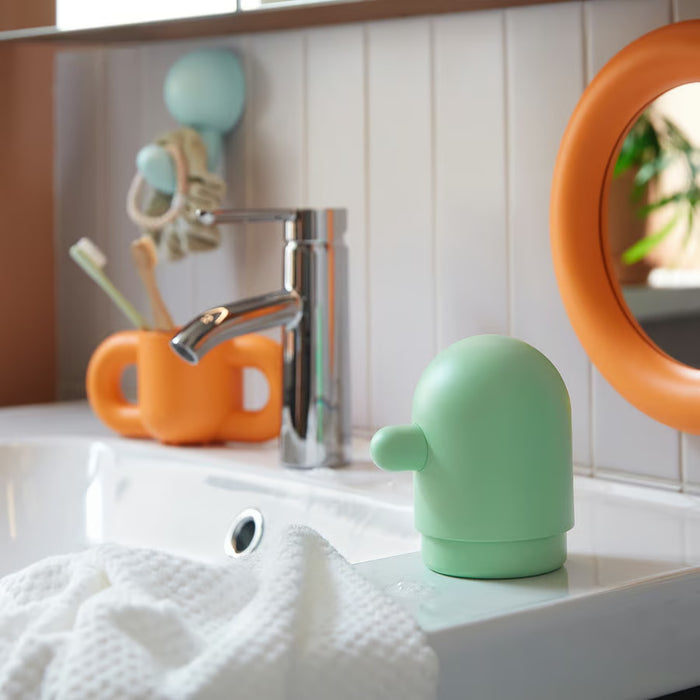 IKEA HUMLESJÖN soap dispenser light green styled in a children's bathroom with toothbrush holder