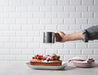 IKEA IDEALISK flour sifter dusting icing sugar over a raspberry and mint topped cake