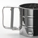 Person dusting blueberries with icing sugar using IKEA IDEALISK stainless steel flour sifter