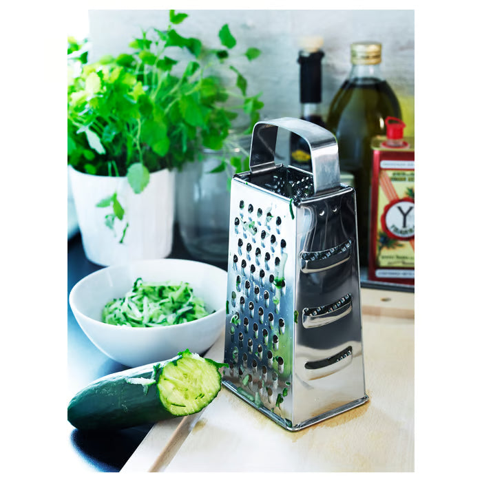 IKEA IDEALISK grater with grated cucumber, bowl and herbs on white kitchen counter