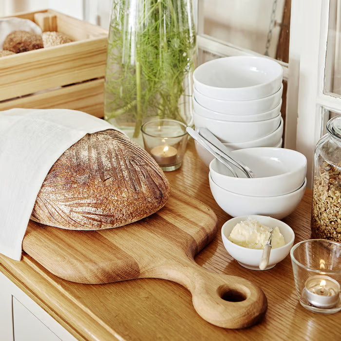 IKEA 365+ white bowl on rustic cutting board with bread granola and cereal breakfast spread