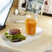 IKEA 365+ clear glass filled with orange juice beside sandwich on wooden dining table