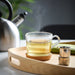  IKEA 365+ glass mug on wooden tray with steaming tea and kettle lifestyle setting