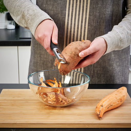  Person peeling vegetables into a bowl using IKEA 365+ VÄRDEFULL black peeler