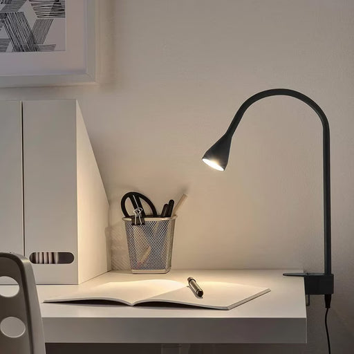 IKEA NÄVLINGE black LED spotlight clamped to a bedside headboard for reading