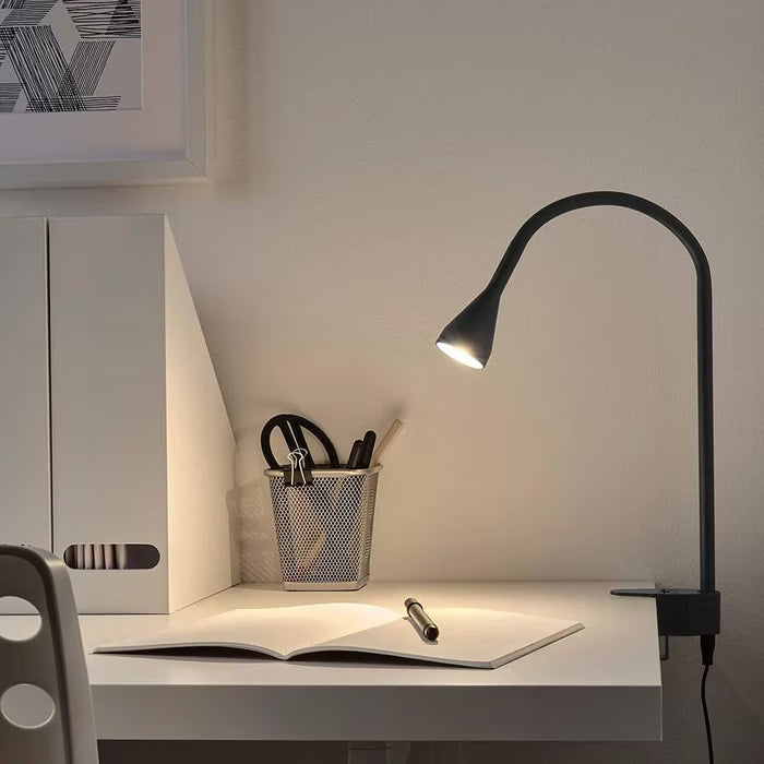 IKEA NÄVLINGE black LED spotlight clamped to a bedside headboard for reading