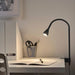 IKEA NÄVLINGE black LED spotlight clamped to a bedside headboard for reading
