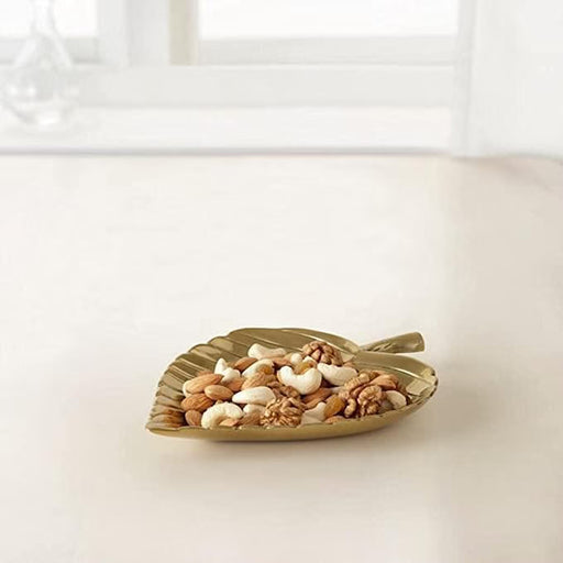IKEA KNASTRIGT gold leaf decoration displayed as table centrepiece with small objects inside dish