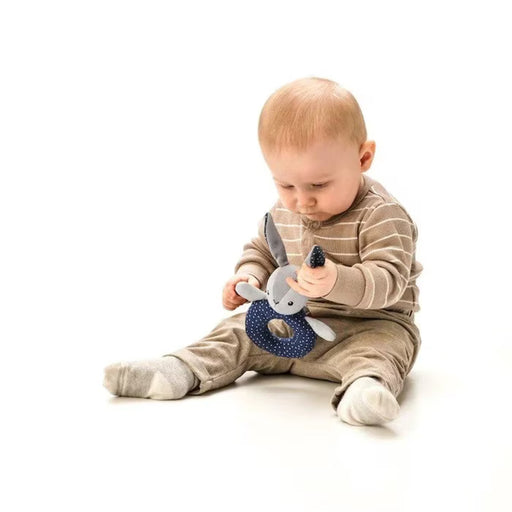 Baby playing with IKEA GULLIGAST grey blue rattle held by adult hand stimulating grip and senses