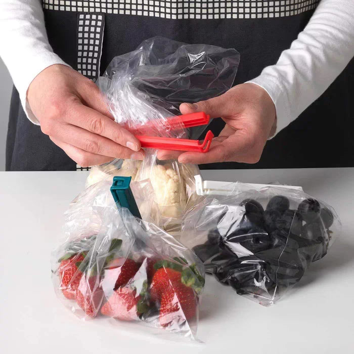 IKEA BEVARA sealing clip in use on a rolled‑up bag of potato chips in a kitchen pantry