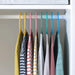 IKEA BAGIS children's coat hangers in blue, pink, and green hanging in a kid's wardrobe

