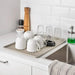 IKEA VÄLVÅRDAD beige dish drainer with plates and cutlery caddy on kitchen counter