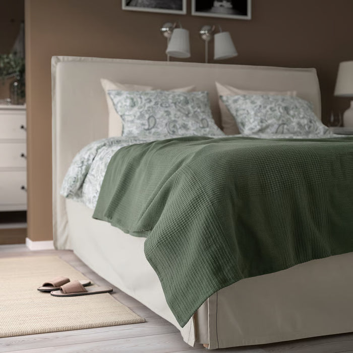 IKEA INDIRA grey-green cotton bedspread styled on a double bed with pillows