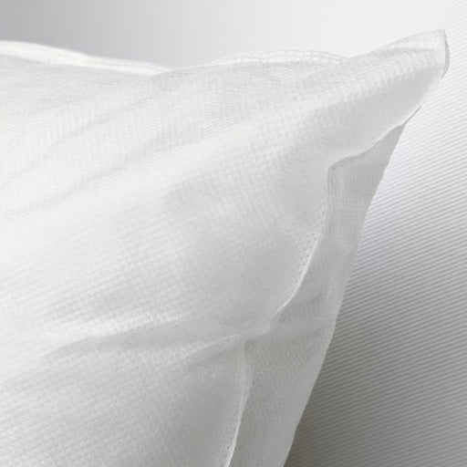 Close-up of IKEA INNER white cushion pad showing soft fluffy texture in natural sunlight