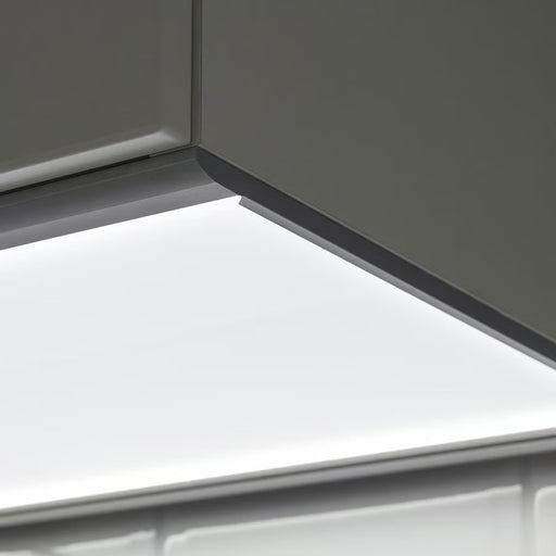 Close-up of a modern gray cabinet corner with a built-in linear LED light glowing brightly against a white background.