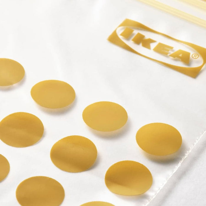  Close-up of gold-coloured IKEA ISTAD double-seal closures scattered on white surface