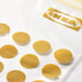  Close-up of gold-coloured IKEA ISTAD double-seal closures scattered on white surface