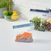  Three IKEA ISTAD blue bags holding vegetables and crackers on a kitchen counter next to citrus fruits