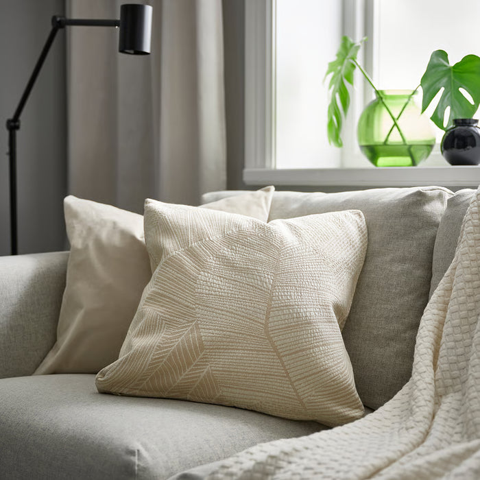 IKEA JÄTTEGRAN off-white cushion styled on grey couch with pillows and blanket