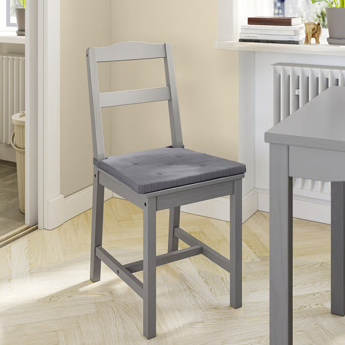 IKEA JUSTINA grey padded seat cushion on a wooden dining chair with simple frame
