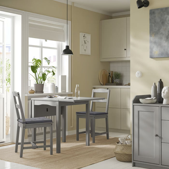 IKEA JUSTINA grey chair pads on dining chairs in a modern kitchen setting near a window