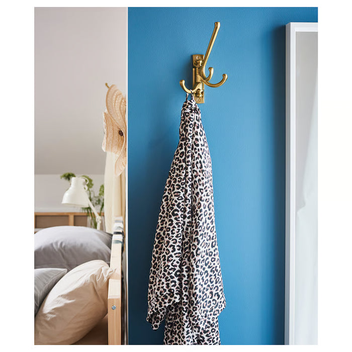  IKEA KÄMPIG brass-colour hook in bedroom with blue wall and leopard-print towel hanging