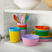 IKEA KALAS kids bowls and cutlery set displayed on a shelf in bright mixed colours