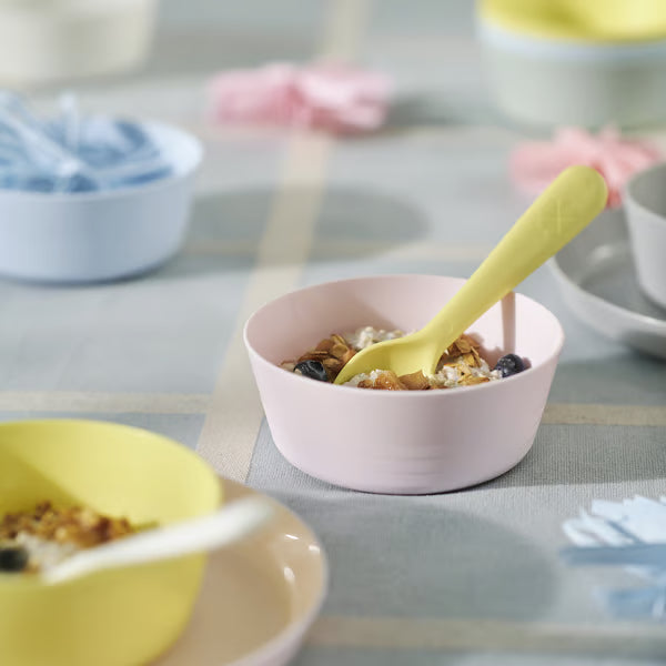 IKEA KALAS yellow kids bowl with oatmeal blueberries and nuts on pink plate with grey spoon