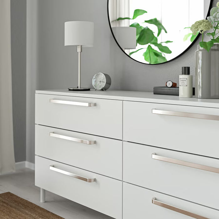 White dresser with IKEA KALERUM silver handles round mirror and decor on top