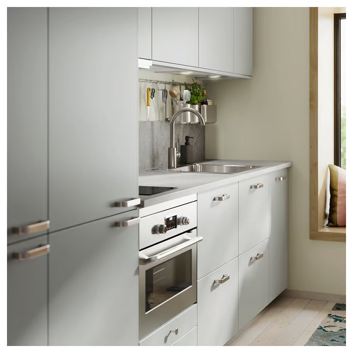 IKEA KALERUM handles on light grey kitchen cabinets with stainless steel appliances minimalist interior