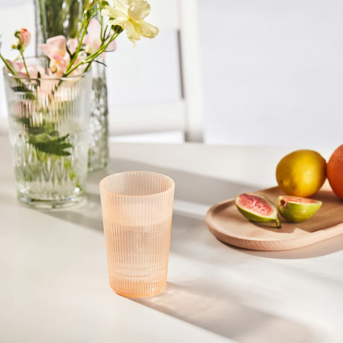 IKEA KALLSINNIG clear plastic glass on a table with fruits and flowers, showing glass-like clarity for picnics