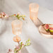  Two IKEA KALLSINNIG orange plastic wine glasses with vertical ribbed texture on white background