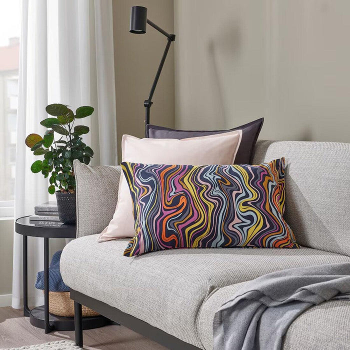 "Colorful IKEA cushion cover with a modern geometric pattern on a sofa.-80571492