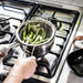 IKEA KLOCKREN colander in semi‑open position, being used as a steamer insert for vegetables