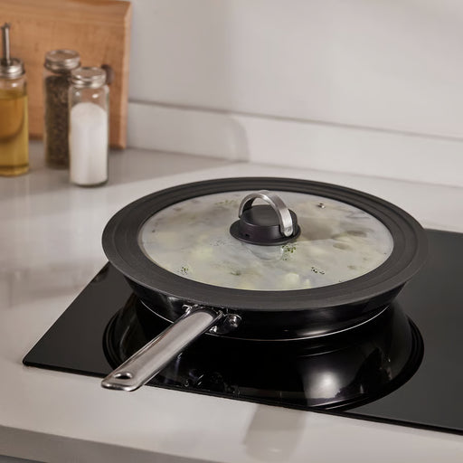 IKEA KLOCKREN glass lid on black pot steaming on stovetop in kitchen setting