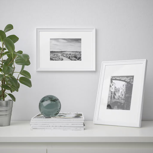 IKEA KNOPPÄNG white picture frame standing vertically on a desk with a family photo