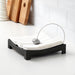 IKEA KNYCK black napkin holder on an outdoor dining table with napkins held in place